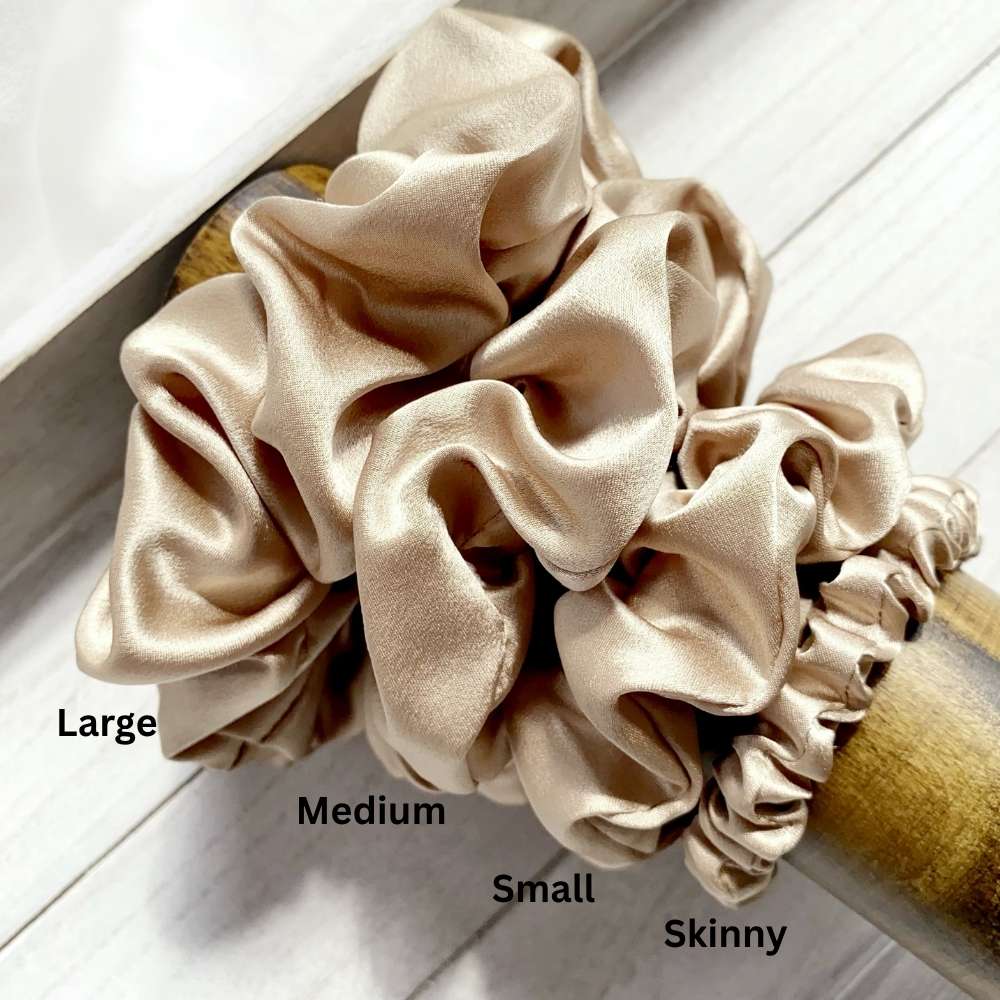 beige khaki silk satin scrunchies of different sizes on a white surface