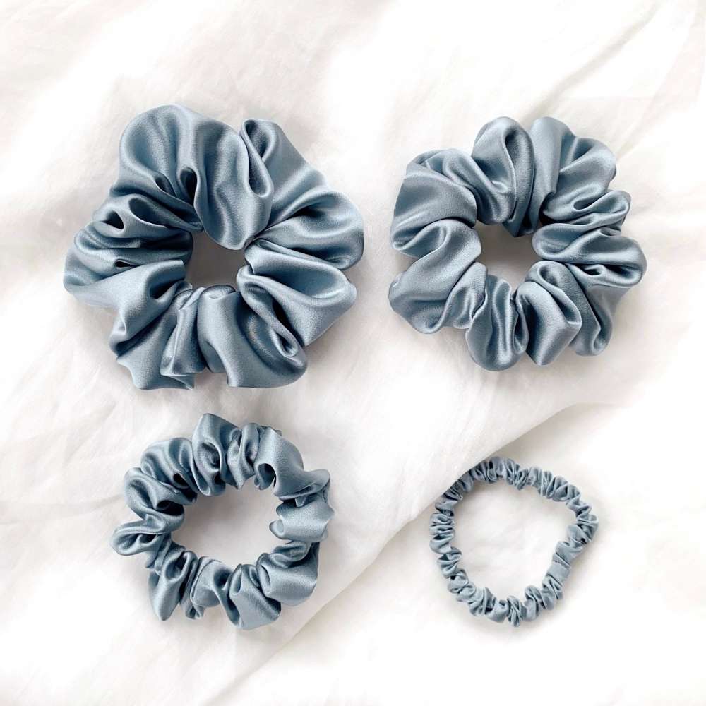 Set of four blue silk hair scrunchies on the white background