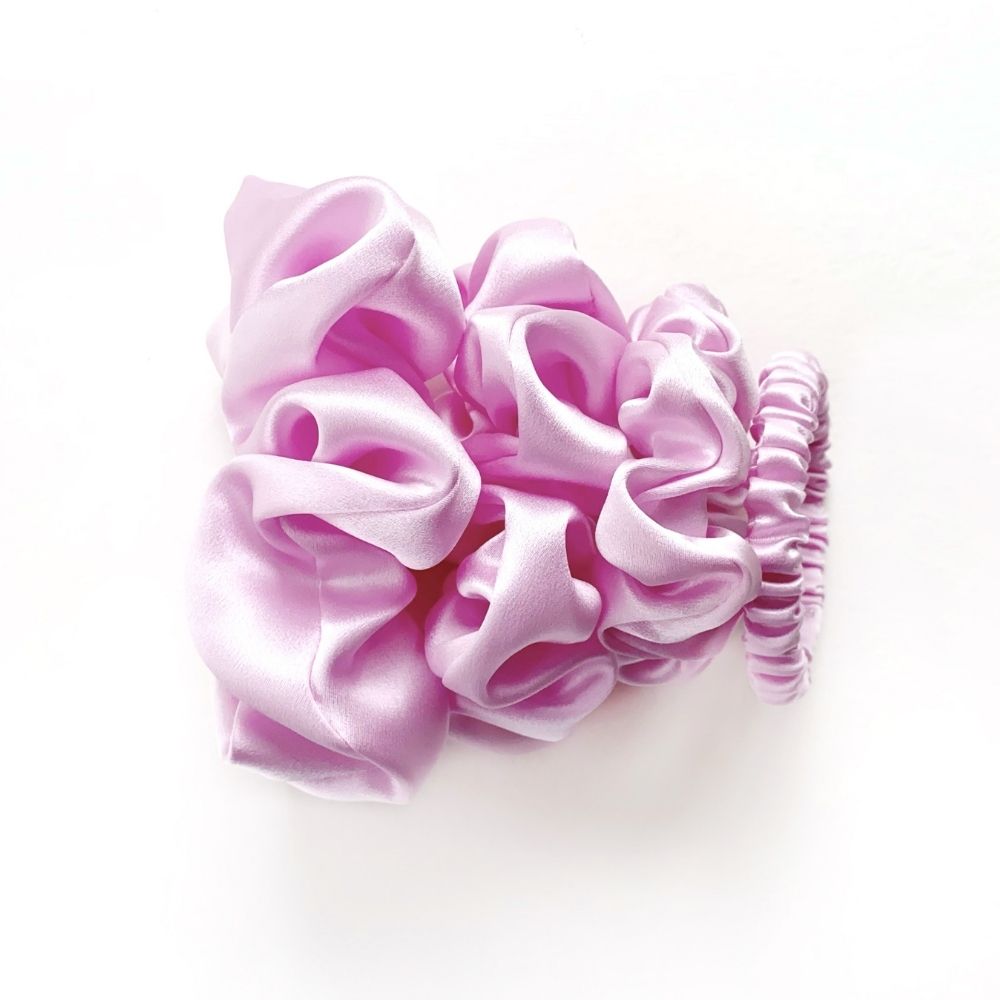 Set of lilac pure mulberry silk satin scrunchies and hair ties on a white background