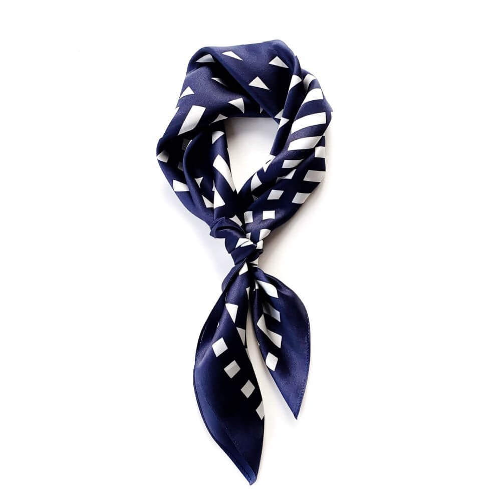Navy blue silk scarf with white geometric pattern on a white background