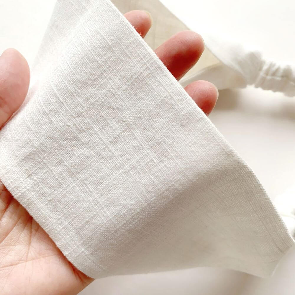 Close-up of a hand holding a white headband.