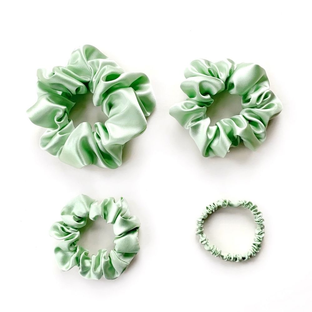 Set of mint green mulberry silk scrunchies and hair ties on a white background
