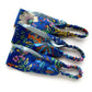 Three  Liberty London mulberry silk satin headbands with colorful  prints on a blue background, arranged diagonally on a white background.