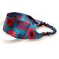 A Liberty London mulberry silk satin headband with a vibrant floral print in teal and red, featuring an elasticized back band, displayed on a white surface.