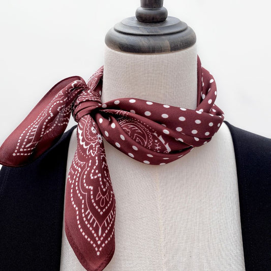 Mannequin wearing a burgundy mulberry silk neck bandana with white polka dots and paisley patterns.