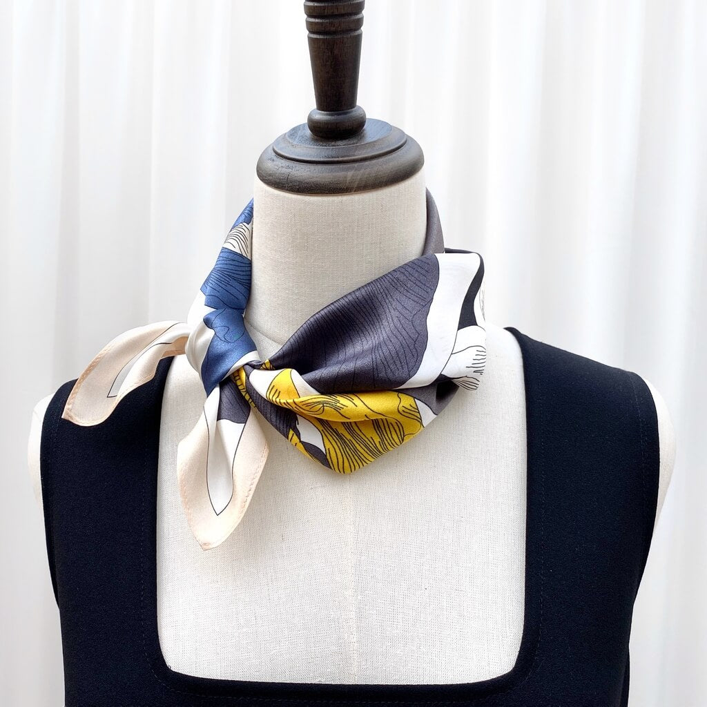 Mannequin wearing a colourful mulberry silk neckerchief with a white background