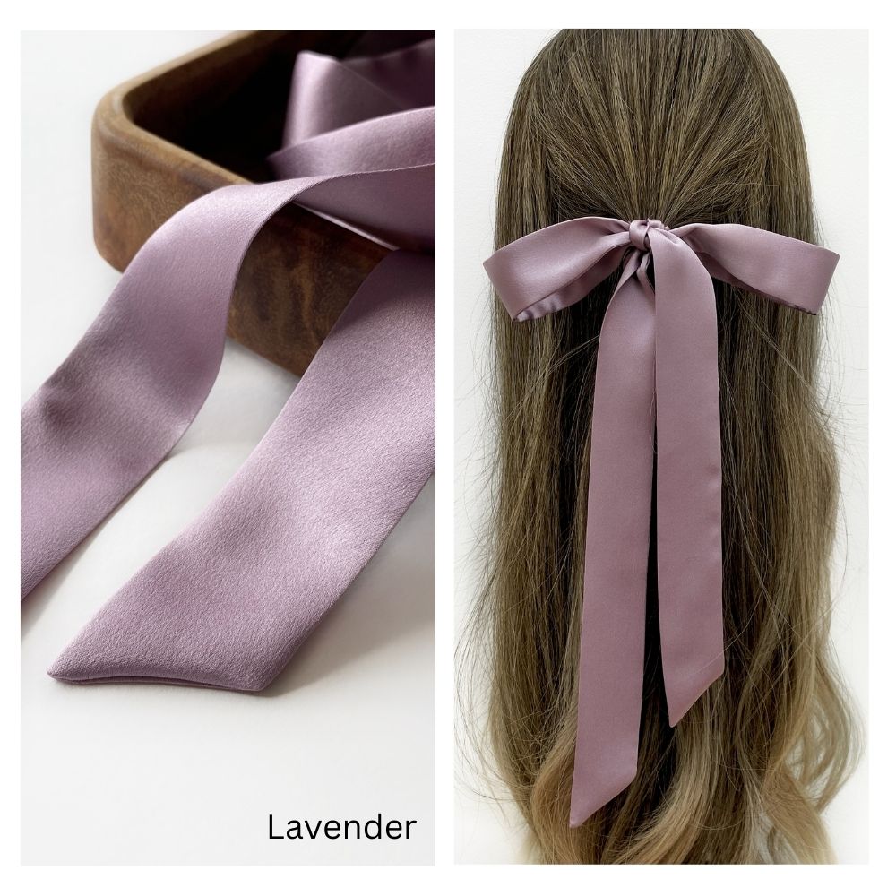 A muted purple mulberry silk satin skinny ribbon scarf tied as a hairbow, styled against a crisp white background.