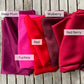 Five pieces of mulberry silk fabric in different colors labeled 'Deep Plum', 'Mulberry', 'Red Berry', 'Red', and 'Fuchsia' on a wooden surface.