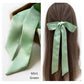 River Minami mint green mulberry silk satin ribbon scarf, styled as a hair accessory.