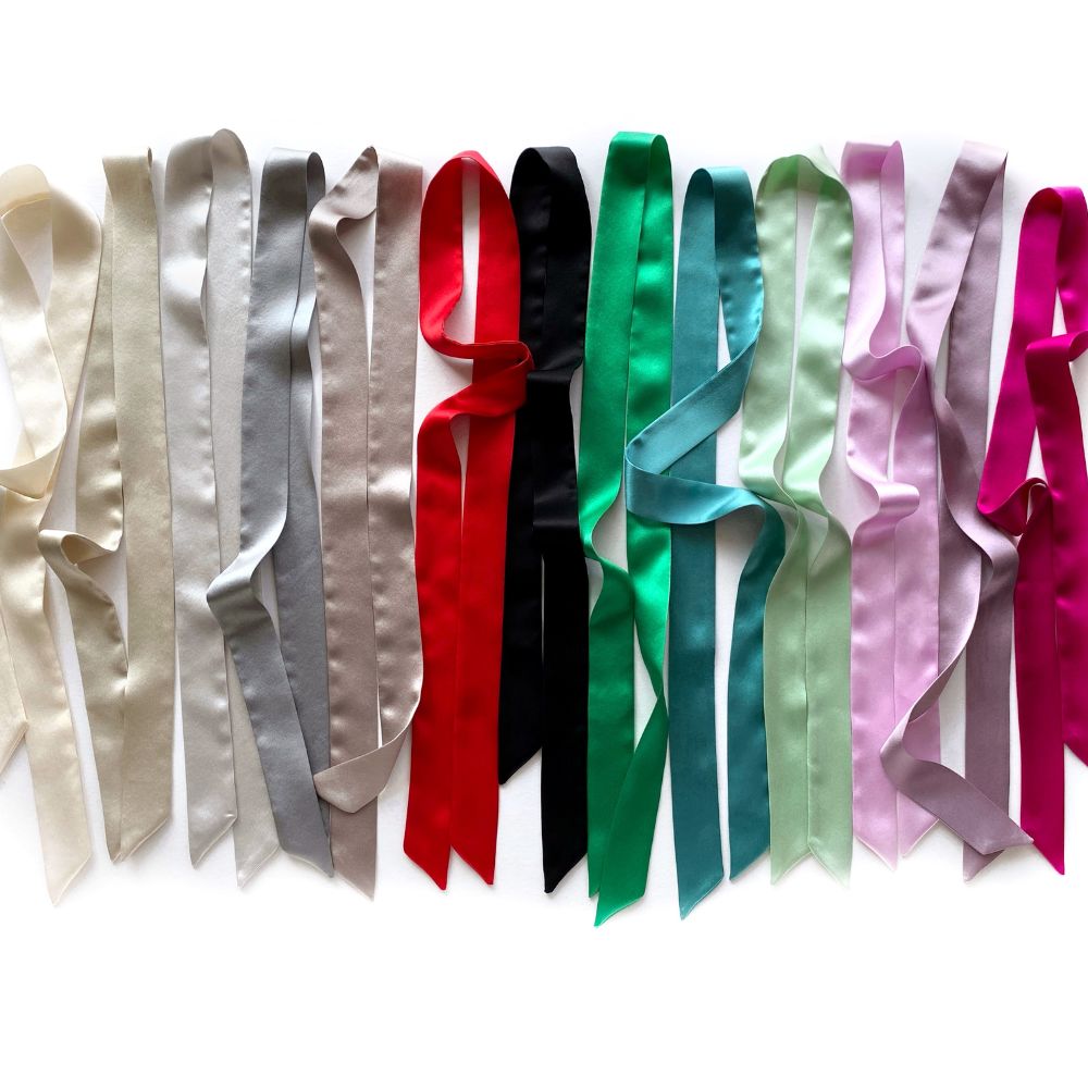 Set of colorful mulberry silk skinny scarf ribbons arranged in a row on a white background