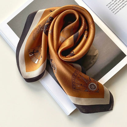 Amber-coloured mulberry silk square scarf with a compass print, placed against a white background.