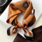 Amber mulberry silk square scarf with a compass print tied into a neckerchief and set on a white background.