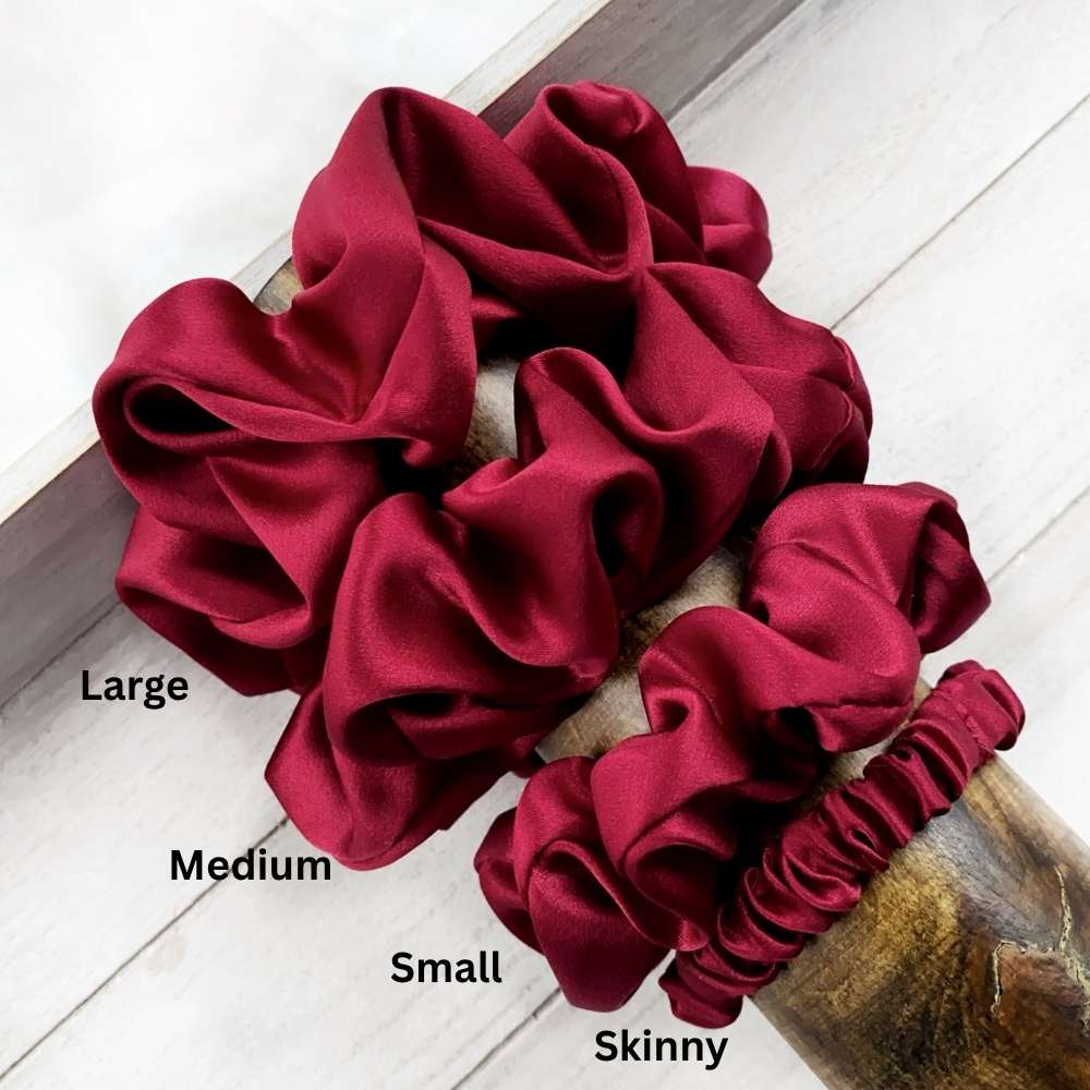 Set of red scrunchies labeled with size on a white surface