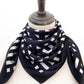 Black and white geometric mulberry silk square scarf on a mannequin with a white background