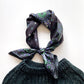 Dark green knitted top with a paisley patterned black and green mulberry silk twill neck bandana scarf on a white background