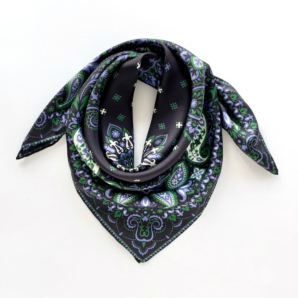 Green paisley patterned black mulberry silk square scarf on a white background