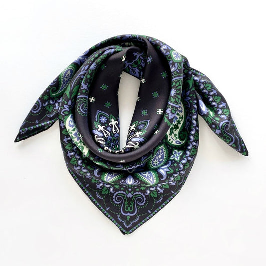 Green paisley patterned black mulberry silk square scarf on a white background