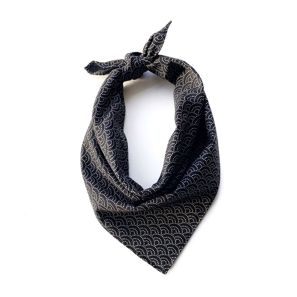 A black Japanese wave print cotton bandana neck scarf tied in a knot at the top and displayed against a plain white background.