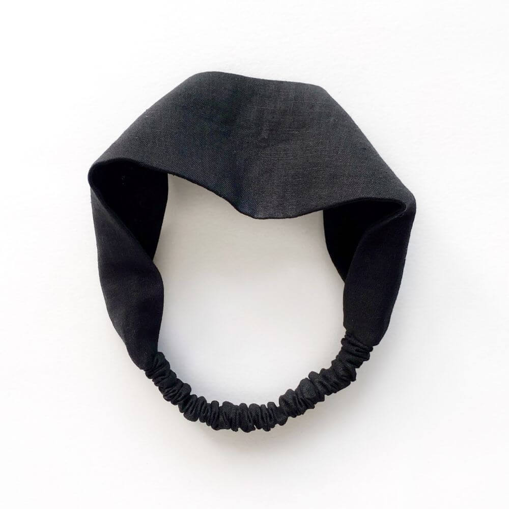 Black linen headband on a white background