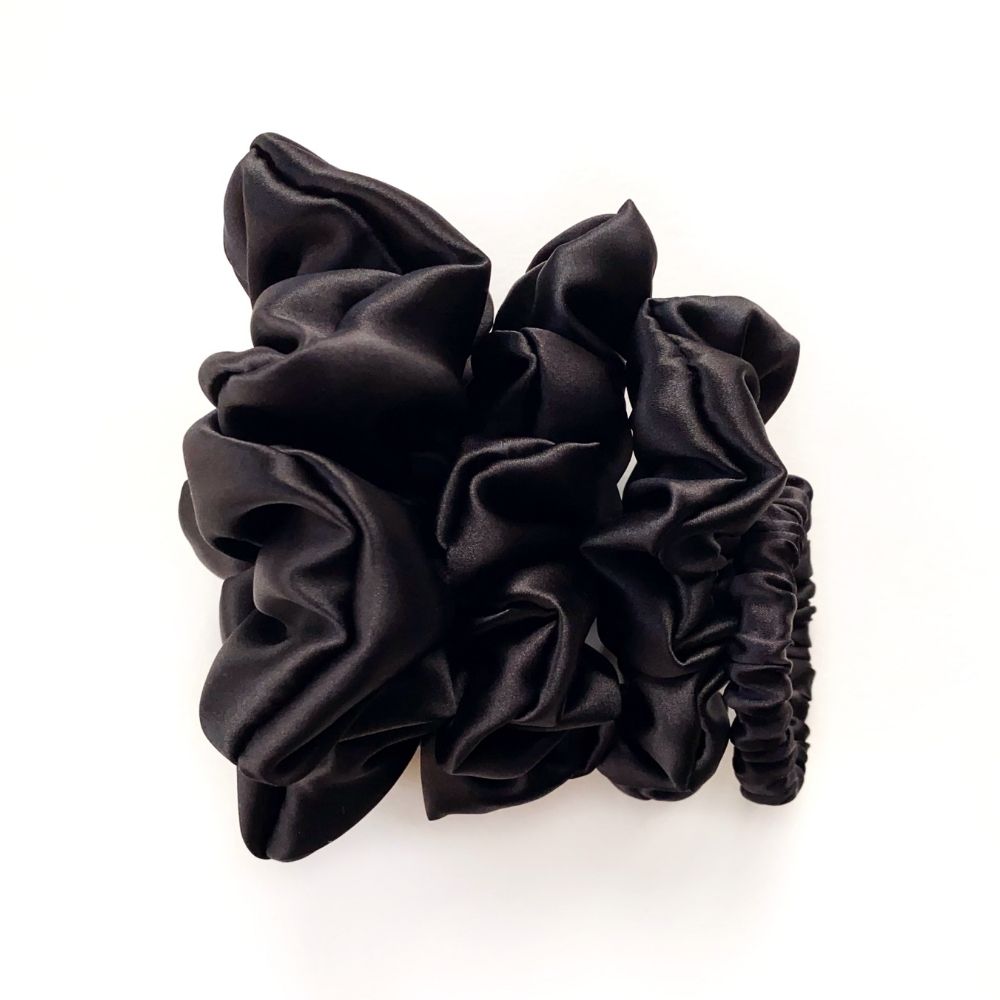 Black mulberry silk scrunchies and hair ties on a white background