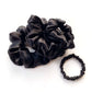 Black mulberry silk scrunchies and hair ties on a white background