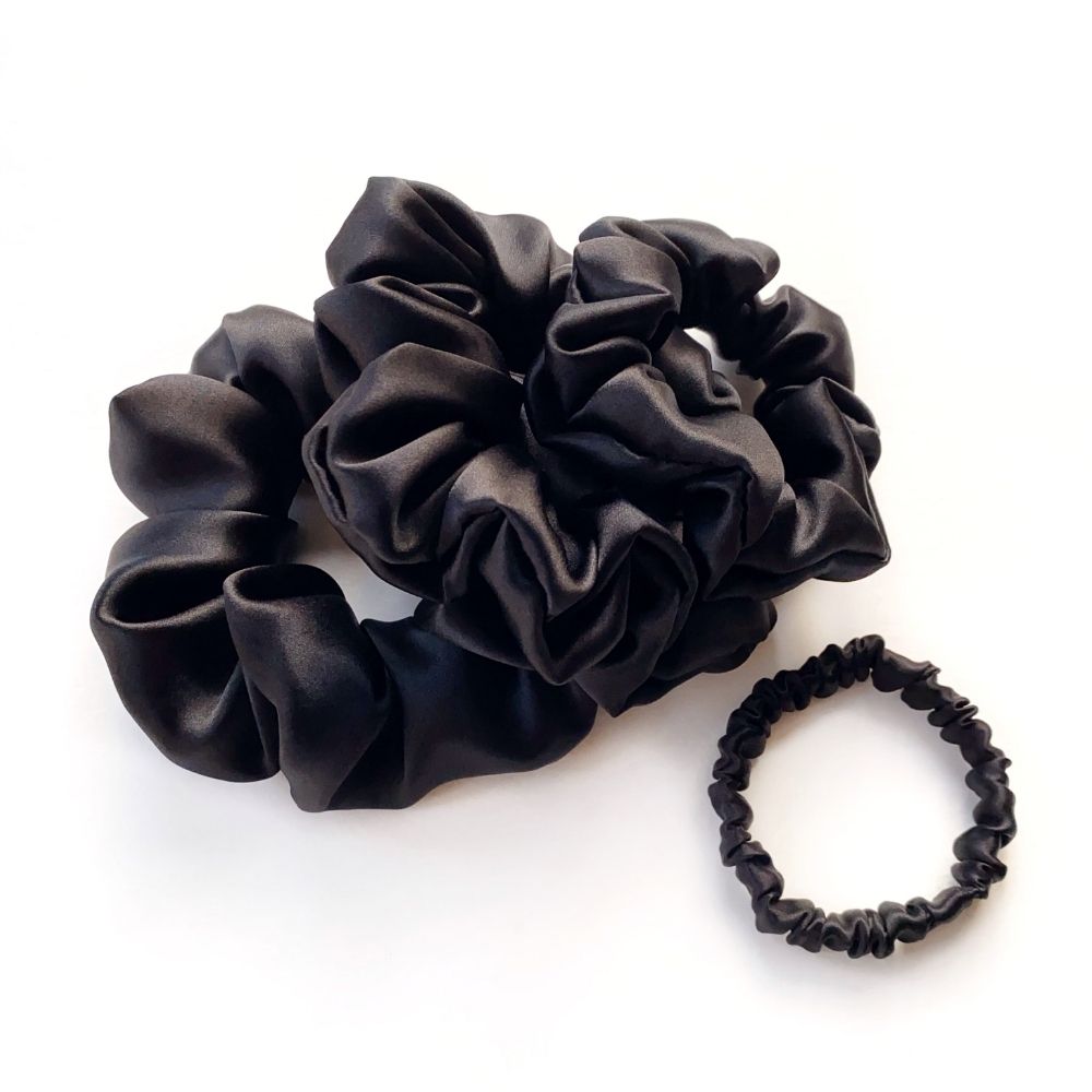 Black mulberry silk scrunchies and hair ties on a white background