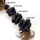 Black mulberry silk scrunchies and hair ties of different sizes on a ponytail with labeled sizes.