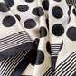 Close-up of black and white polka dot silk scarf with stripes