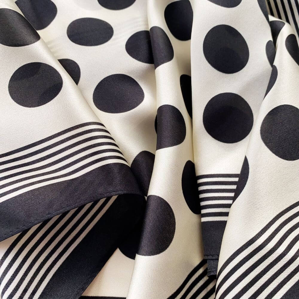 Close-up of black and white polka dot silk scarf with stripes