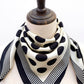 Black and white polka dot silk scarf on a mannequin's neck