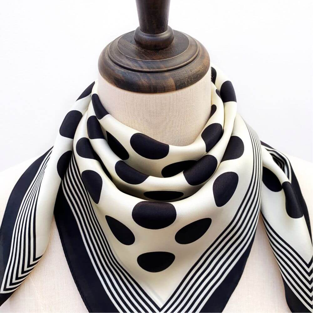 Black and white polka dot silk scarf on a mannequin's neck