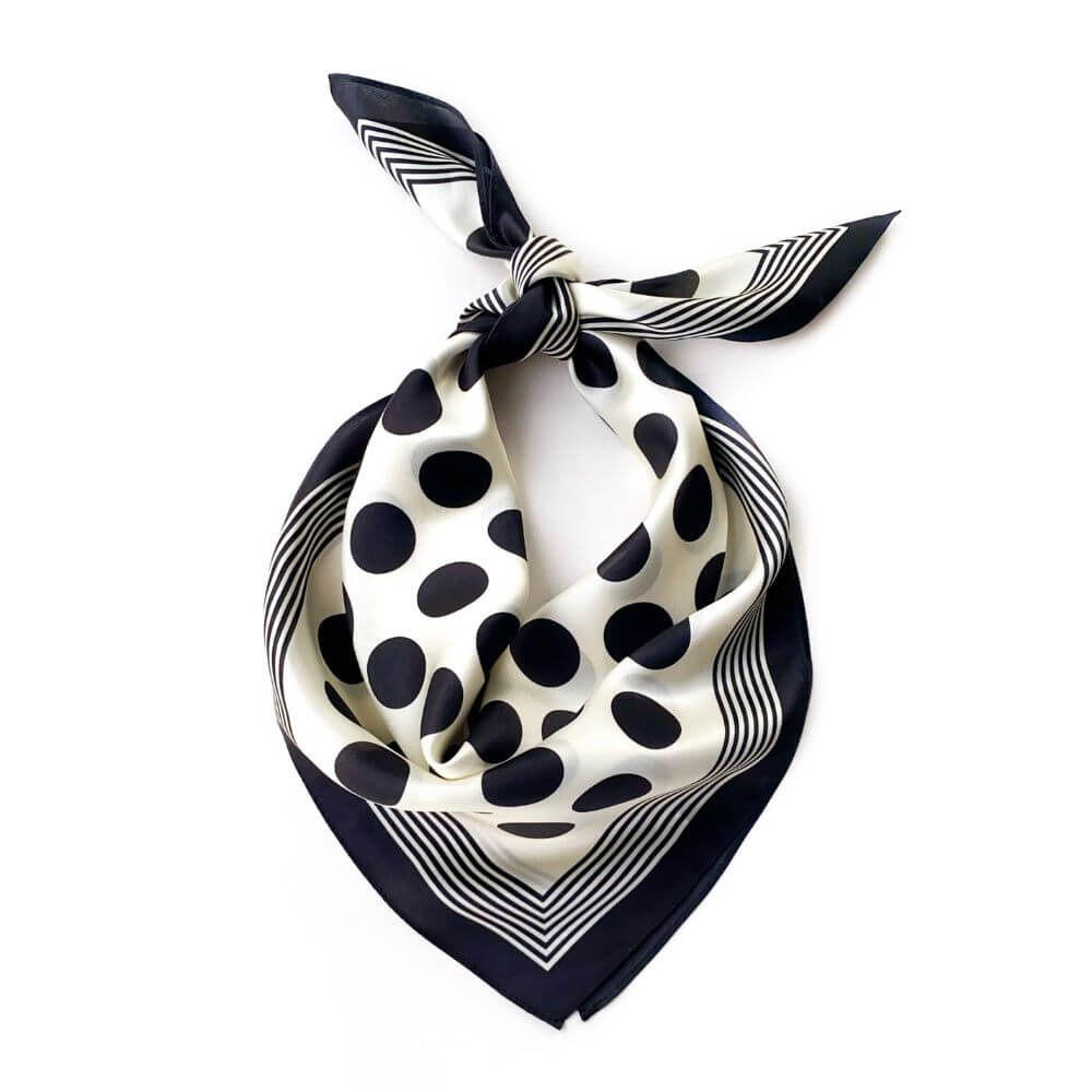 Black and white polka dot silk scarf on a white background