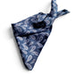 Blue paisley print mulberry silk square scarf tied into a triangle, placed on a white background