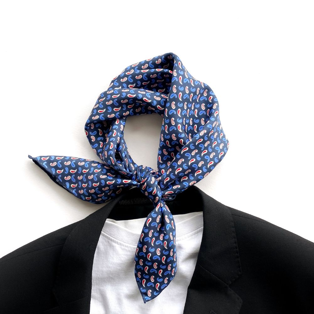 navy blue paisley patterned mulberry silk square neck scarf tied around a collar with a black suit and white t shirt