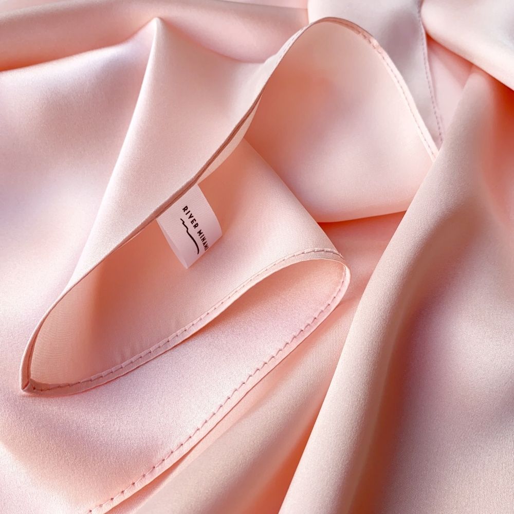 Close-up of blush pink 16 momme Mulberry silk fabric and stitching
