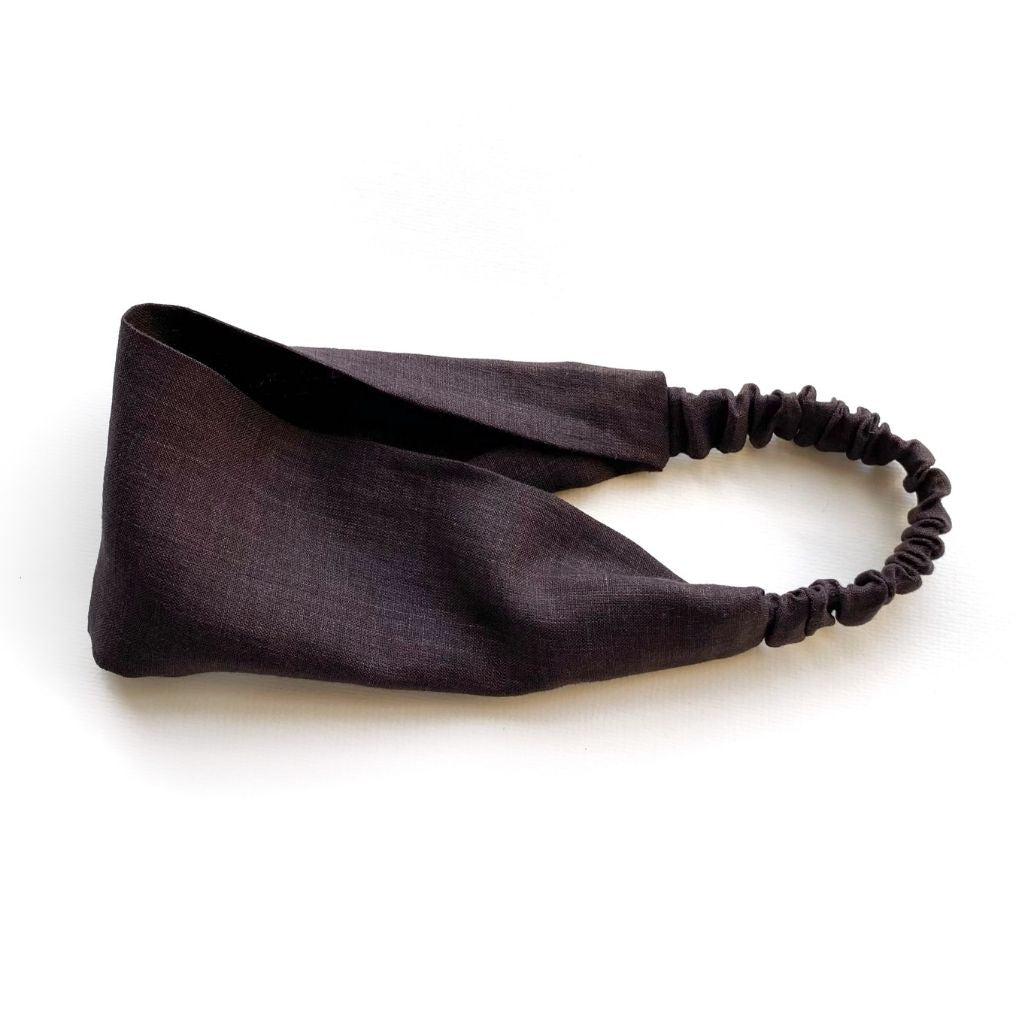 A dark brown  flat linen headband with an elastic back, displayed on a clean white background.