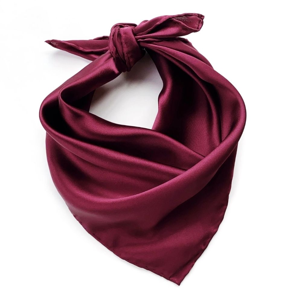 Maroon silk scarf tied in a knot on a white background