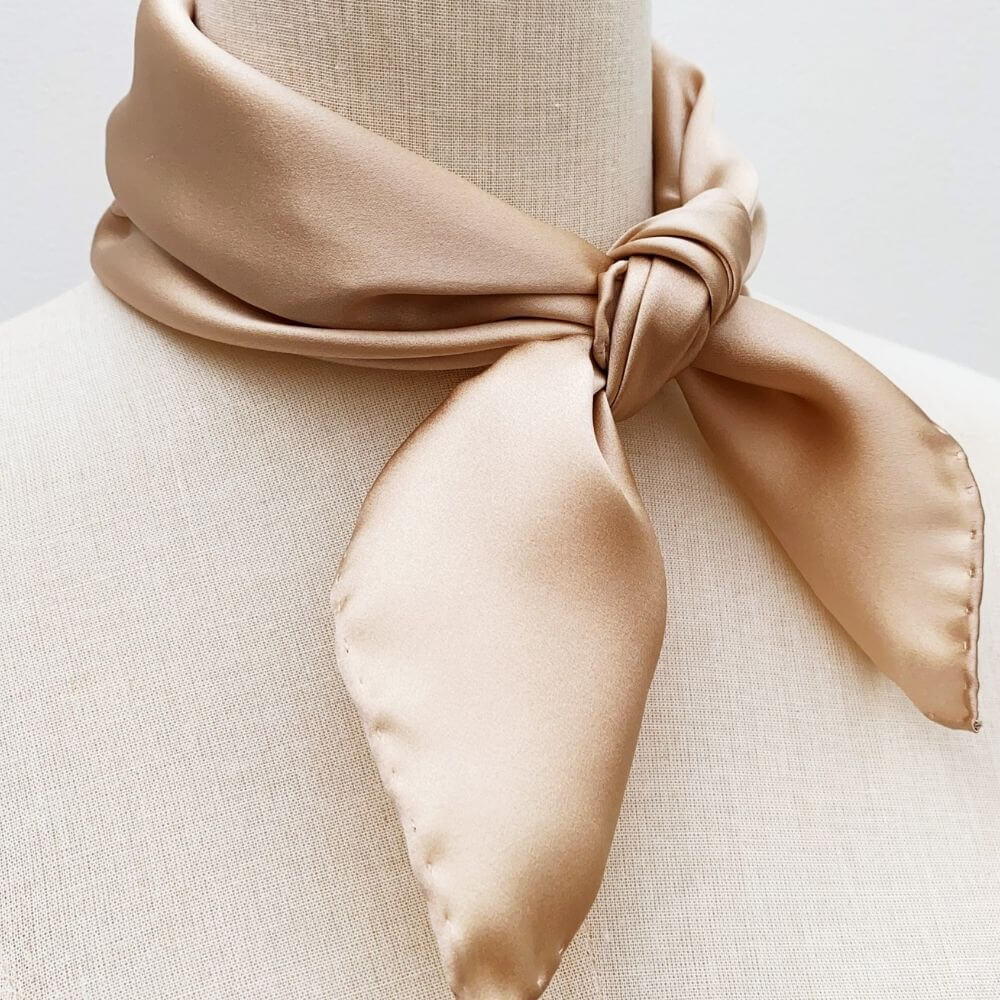 Champagne beige silk square scarf styled in a classic neck knot on mannequin