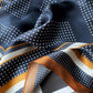 close up of a navy blue geometric print mulberry silk square bandana scarf