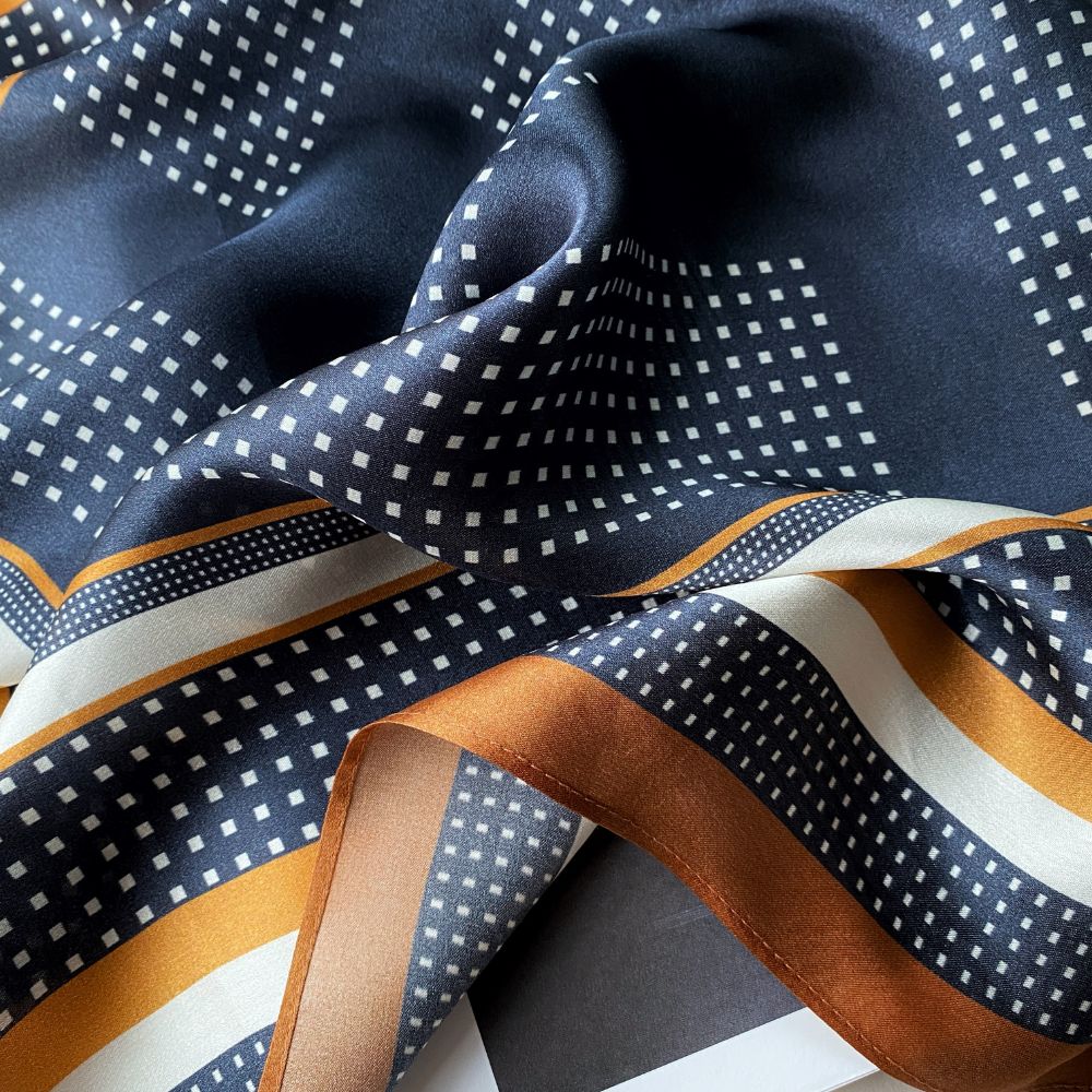 close up of a navy blue geometric print mulberry silk square bandana scarf