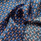 Close-up of a mulberry silk square scarf with blue, red, and white paisley pattern