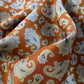 Close-up of caramel orange brown mulberry silk bandana scarf with blue and white paisley pattern