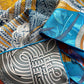 close up of a mulberry silk twill square scarf with blue yellow and grey colours