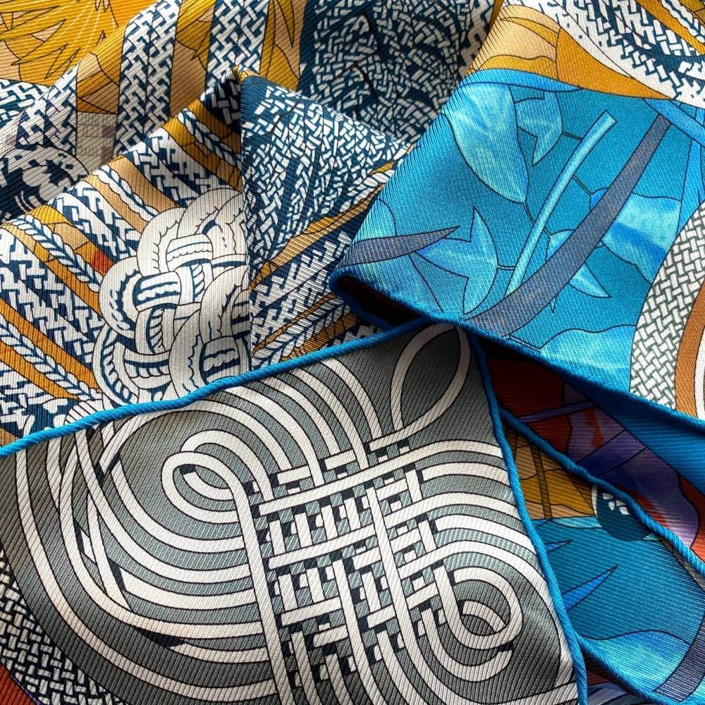 close up of a mulberry silk twill square scarf with blue yellow and grey colours