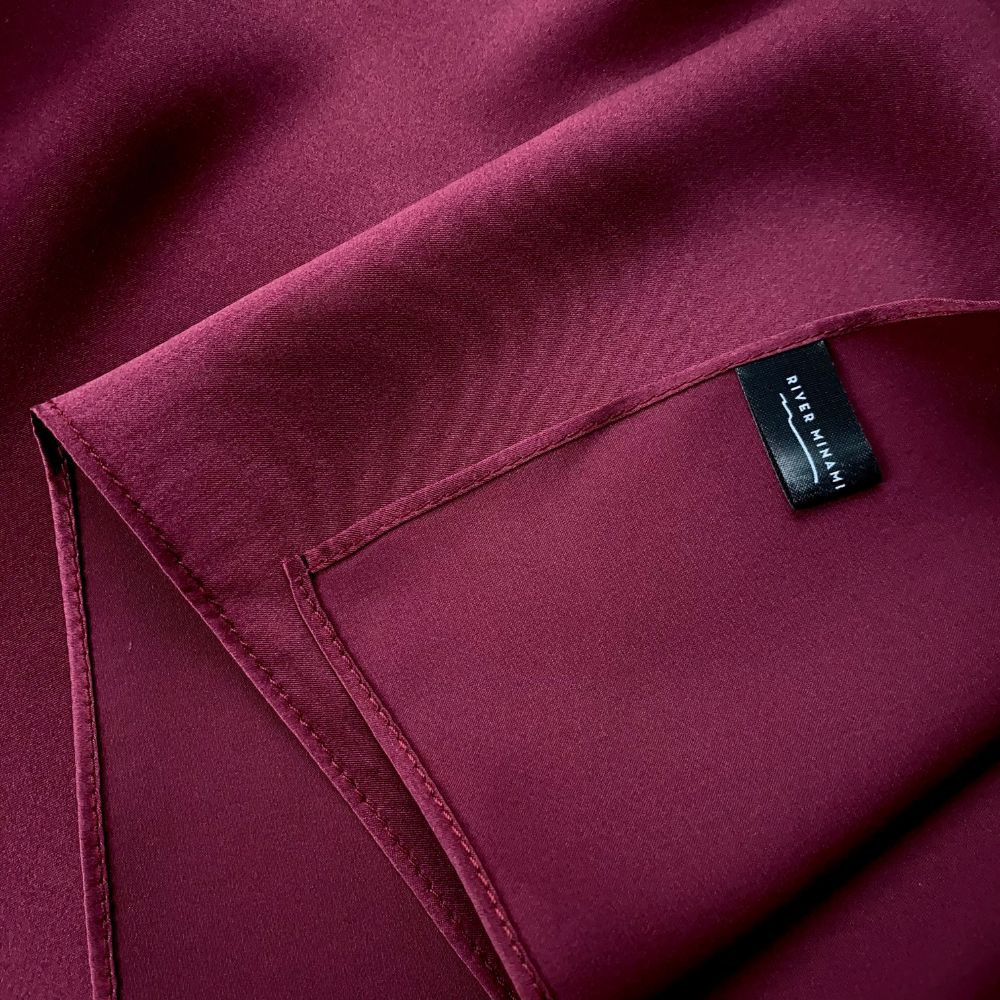 closed up of a burgundy mulberry silk square scarf with river minami label