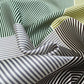 close up mulberry silk square scarf with green, light grey, yellow and white stripes.