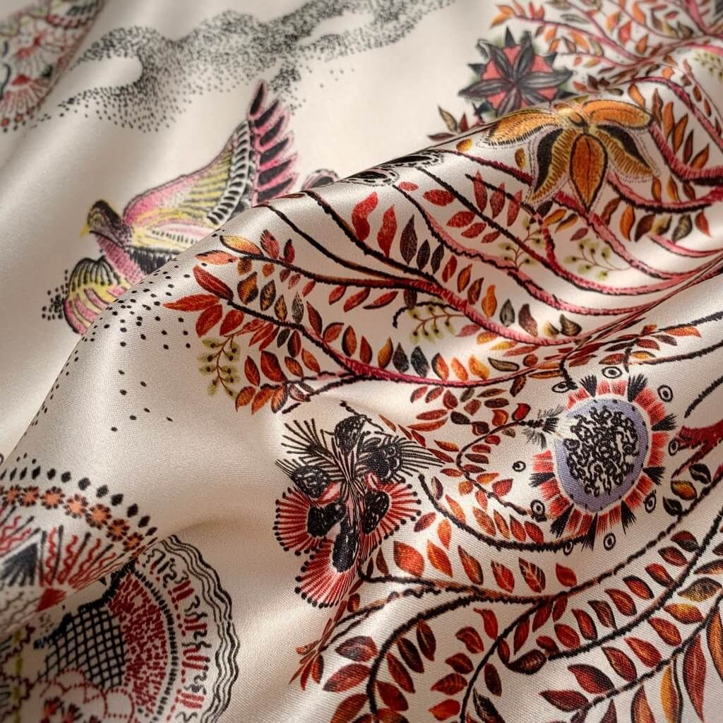 close up of an ivory beige mulberry silk square scarf with burnt orange leafy pattern