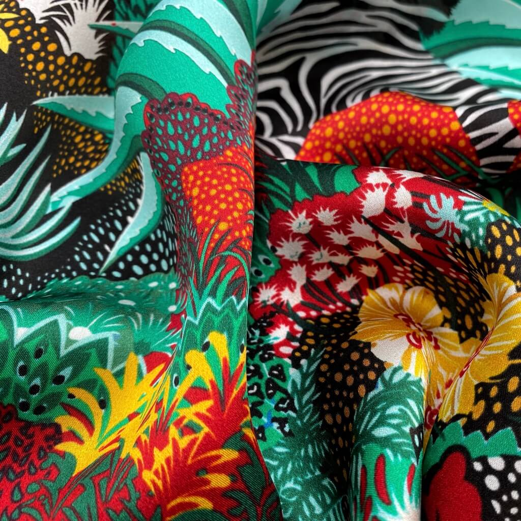 Close-up of bold green red yellow mulberry silk square scarf with tropical and zebra designs.