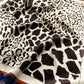close up a mulberry silk scarf with a black and ivory animal print pattern