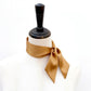 copper brown mulberry silk satin skinny scarf tied around mannequin's neck